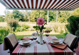 a table with a vase with a pink flower on it at Euskal Herria in Saint-Pée-sur-Nivelle