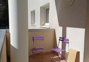two purple chairs sitting in front of a building at Appartement T2 in Digne-les-Bains