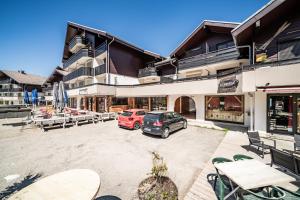a parking lot with cars parked in front of a building at Entre Lac Et Montagne in Thollon