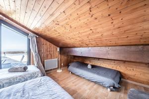 two beds in a room with a wooden ceiling at Entre Lac Et Montagne in Thollon