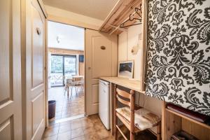 a kitchen with a table and a chair in a room at Entre Lac Et Montagne in Thollon