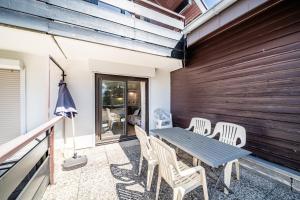 a table and chairs on the balcony of a house at Entre Lac Et Montagne in Thollon