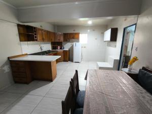 a kitchen with wooden cabinets and a table in it at Recanto do Sabiá Center in Chapecó