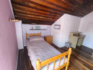 a bedroom with a wooden bed and a wooden ceiling at Recanto do Sabiá Center in Chapecó