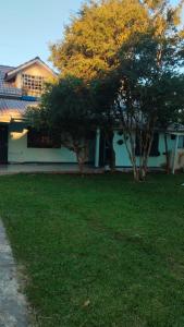 a house with trees in front of a yard at Recanto do Sabiá Center in Chapecó