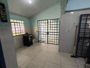 a room with two doors and a tiled floor and a room with at Recanto do Sabiá Center in Chapecó