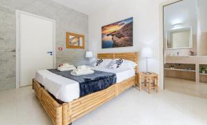 a bedroom with a large bed and a bathroom at Baia Verde - Sea Rooms in Baia Verde