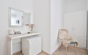 a white room with a chair and a mirror at Apartment & Rooms Meri Tučepi in Tučepi +106 photos