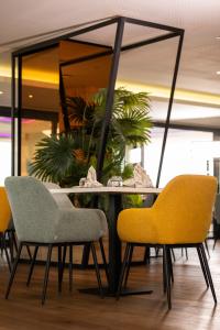 a table with two chairs and a mirror at AZ Appart hotels Saitour in Mazagran