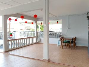 a room with a table and chairs on a balcony at Aplus Homestay Kluang A嘉民宿 in Kluang
