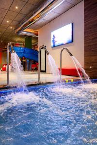 a swimming pool with water shooting out of it at AZ Appart hotels Saitour in Mazagran