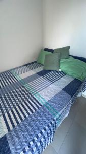 a large bed with blue and green pillows on it at Full Studio in Stella Maris in Salvador +14 photos