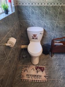a bathroom with a toilet and a rug at Guesthouse at Lucia in Bethlehem