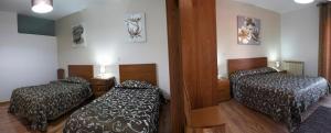a bedroom with two beds and a desk at Flor Do Douro in Miranda do Douro