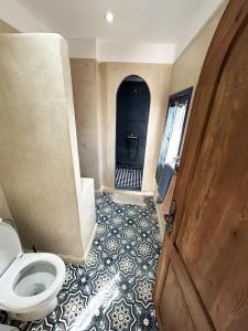 a bathroom with a toilet and a blue and white floor at Riad D’AR GANne by Carole in Essaouira