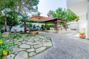 a patio with a bench and an umbrella at Baia Verde - Sea Rooms in Baia Verde