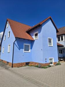 a blue house with a red roof at Daheim in Burk in Burk