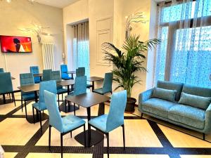 a dining room with blue chairs and tables at Verona Class ApartHotel "Residenze del Cuore" in Verona