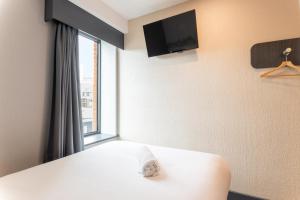 a bedroom with a white bed with a window at easyHotel Oxford in Oxford