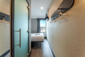 a small room with a bed and a door to a bedroom at easyHotel Oxford in Oxford +64 photos
