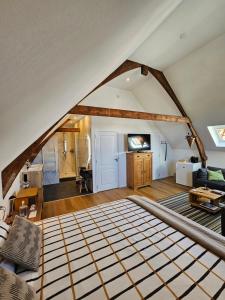 an attic living room with a large bed in it at B&B van Zon aan Zee in Vlissingen