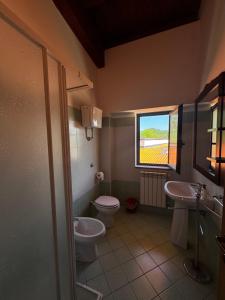 a bathroom with a toilet and a sink and a window at La terrazza del cilento in Perito