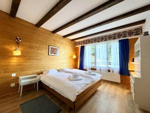 a bedroom with a large bed and a window at Cache-Cache MOUNTAIN & QUIET chalet 10 pers in Veysonnaz
