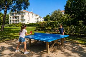 a boy and a girl playing a game of ping pong at Le VALLON à POR-NIC in Pornic