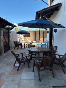 a group of picnic tables and umbrellas on a patio at Pousada Casa do Telhado Verde in Cabo Frio