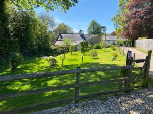 a wooden fence in front of a yard with houses at Cranbrook on the river lym walk in Uplyme in Uplyme