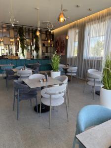 a restaurant with tables and chairs and plants at Hotel President in Čapljina