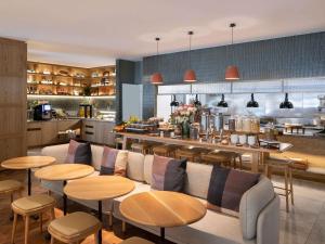 a restaurant with a couch and tables and a kitchen at Novotel Sydney City Centre in Sydney
