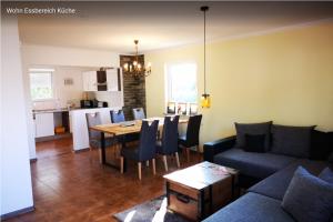 a living room with a couch and a table and a kitchen at Haus Birkenblick in Rimbach