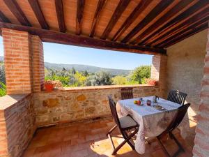 a patio with a table and chairs and a large window at Agriturismo e Glamping Serraiola Alta in Frassine