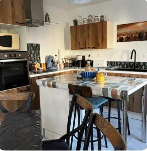 a kitchen with a counter and some chairs in it at Petit gîte a côté des plages in Triaize
