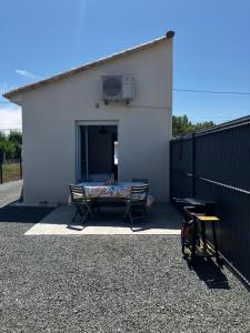 a white building with a bench in front of it at Petit gîte a côté des plages in Triaize +4 photos