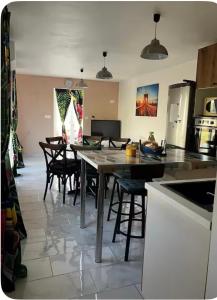 a kitchen with a table and chairs in a room at Petit gîte a côté des plages in Triaize