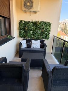a patio with a couch and chairs on a balcony at Nanna apartman in Ruma