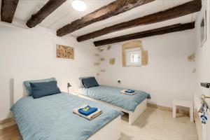 two beds in a room with white walls and wooden ceilings at Villa Amanda by CVR in Roústika +127 photos