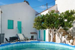 a swimming pool in front of a house with a tree at Villa Amanda by CVR in Roústika