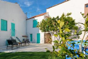 a patio with two chairs and a table in front of a building at Villa Amanda by CVR in Roústika