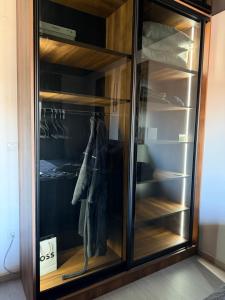 a wardrobe with glass doors and hangers at Nanna apartman in Ruma