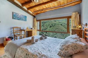 a bedroom with a bed and a large window at Casa Alfurán in Alfornón