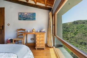 a bedroom with a bed and a desk and a window at Casa Alfurán in Alfornón