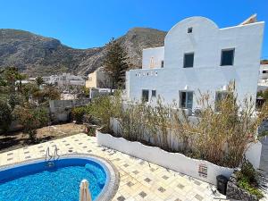 a house with a swimming pool in front of a house at Villa Galathea in Kamari