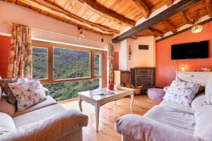 a living room with two couches and a large window at Casa Alfurán in Alfornón