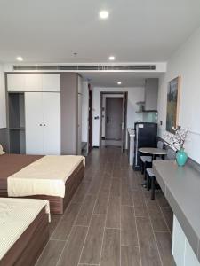 a room with two beds and a table and a kitchen at Homestay- Phòng nghỉ Lazur Cửa Lò in Giáp Vinh Yên