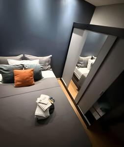 a mirror reflection of a bedroom with a bed and a couch at Safiras Premium | Seu conforto em Cuiabá in Cuiabá +63 photos