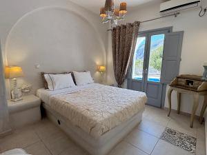 a white bedroom with a bed and a window at Villa Galathea in Kamari +73 photos