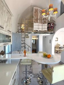 a kitchen with a white counter and a table and chairs at Villa Galathea in Kamari